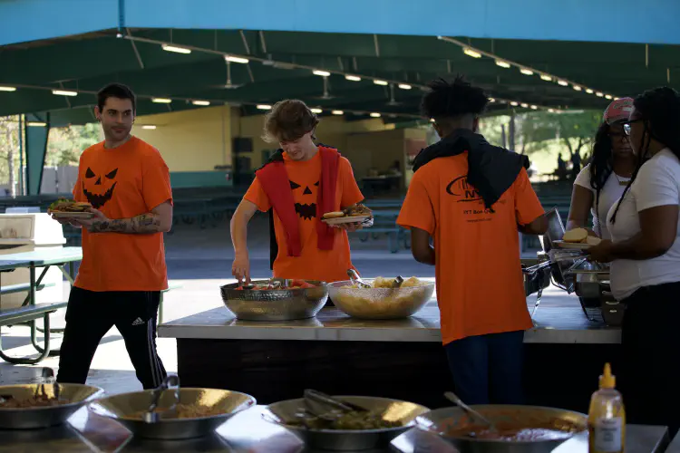 Teens getting food at outdoor banquet