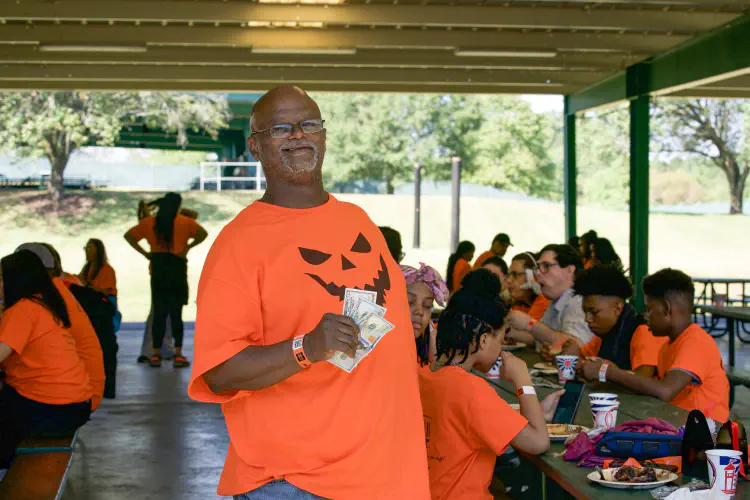 Man smiling holding money at banquet